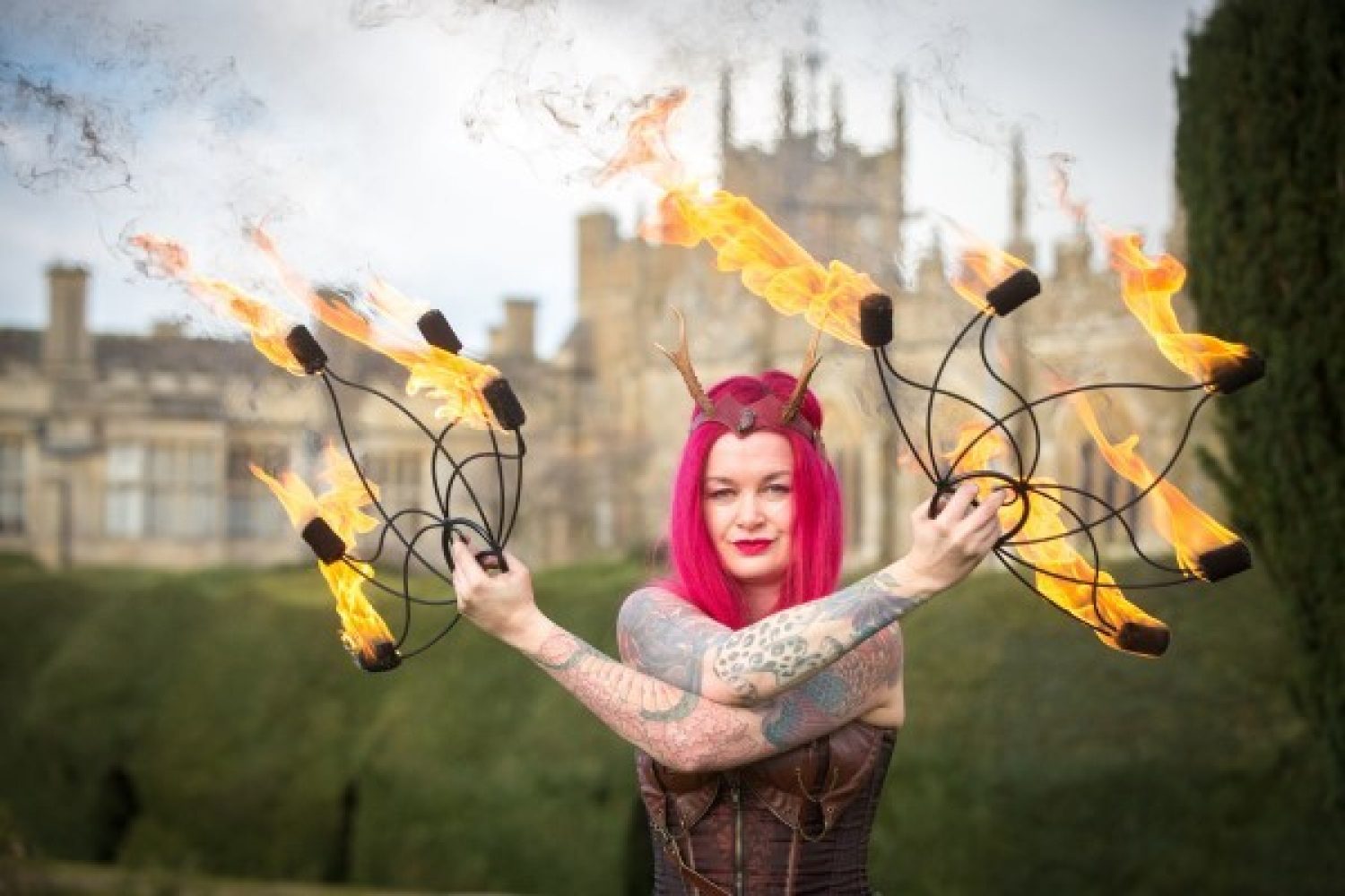 A female performer holds flaming objects