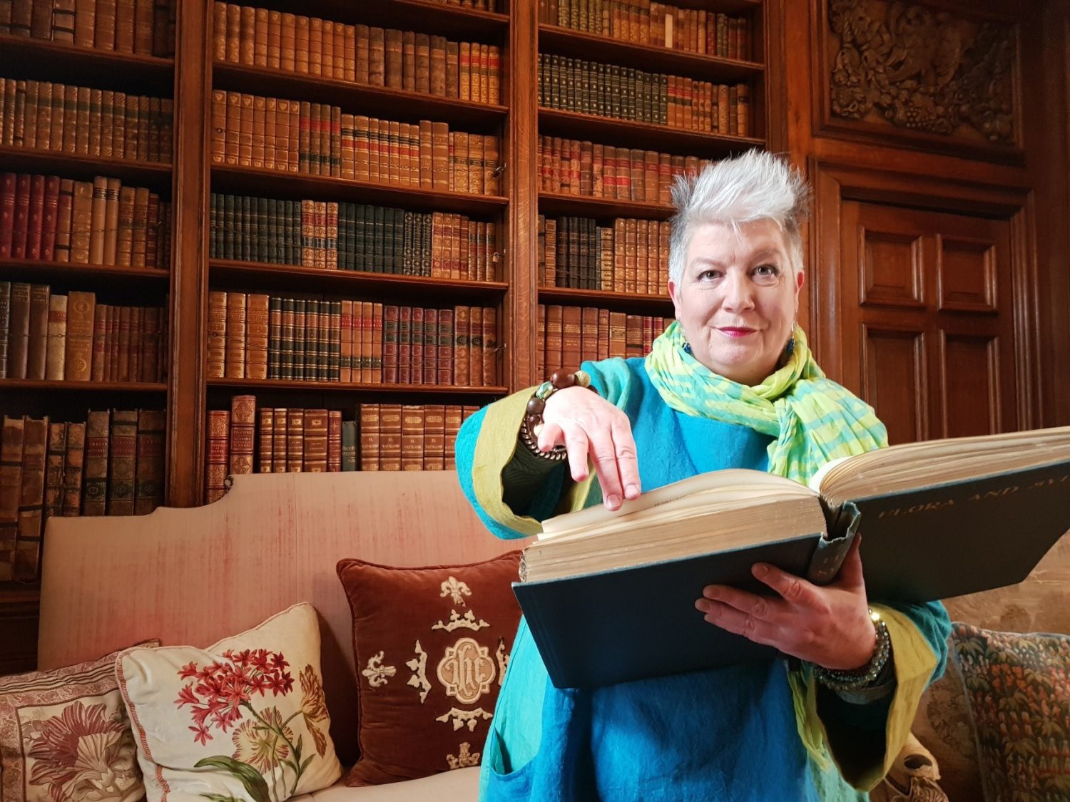 Midnight Storyteller with large book in front of library