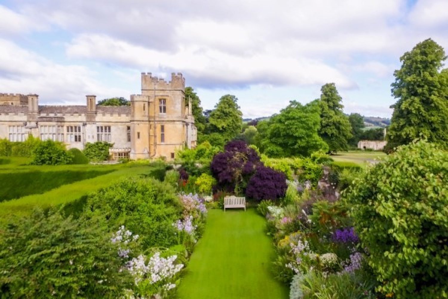 Aerial shot above Sudeley's lawns. Lush grass and flower blooms in abundance.