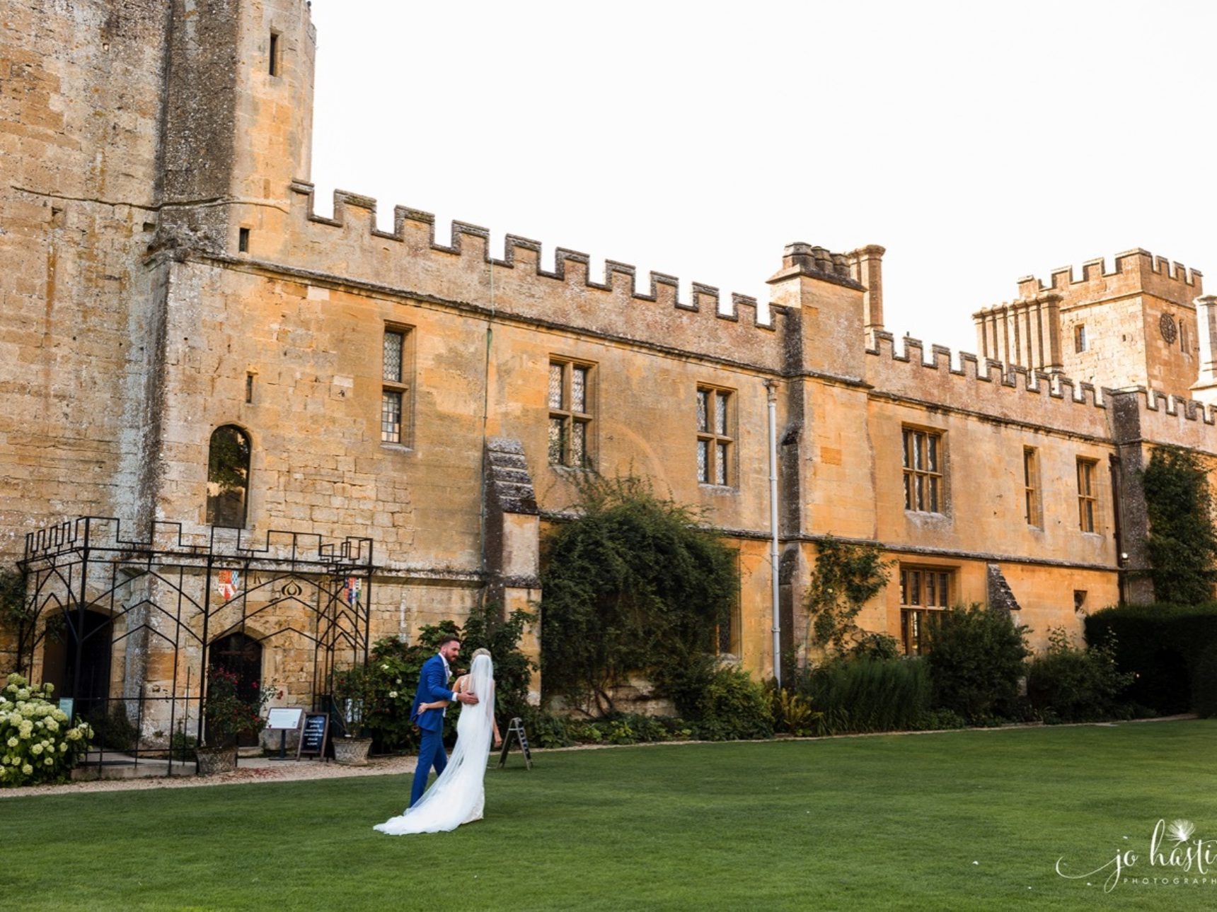 Wedding couple walking along Mulberry Lawn with Castle backdrop